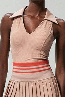 Person wearing a pink pleated dress with a white background